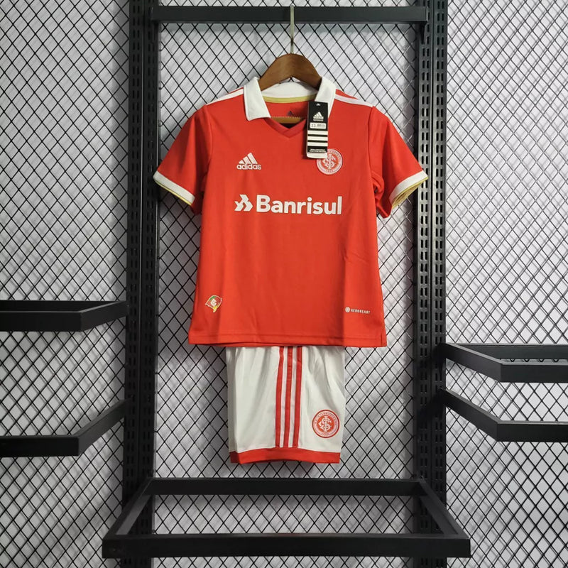 Kit Infantil Internacional Home 2022/23 Adidas na cor vermelha com shorts branco, uniforme oficial para crianças com escudo do Inter e logo Adidas, tecido leve e confortável.