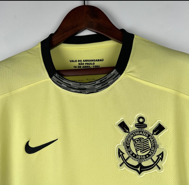 Camisa Corinthians Third III 2023/24 Nike torcedor masculina amarela, com escudo do clube bordado no peito, detalhes em preto e design inspirado na Democracia Corinthiana