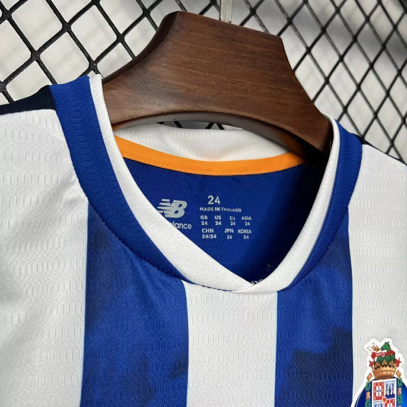 Kit Infantil FC Porto Home I 2024/25 New Balance, camisa azul e branca com listras verticais, escudo oficial do clube, tecido leve e confortável, conjunto completo com shorts para crianças de 3 a 13 anos
