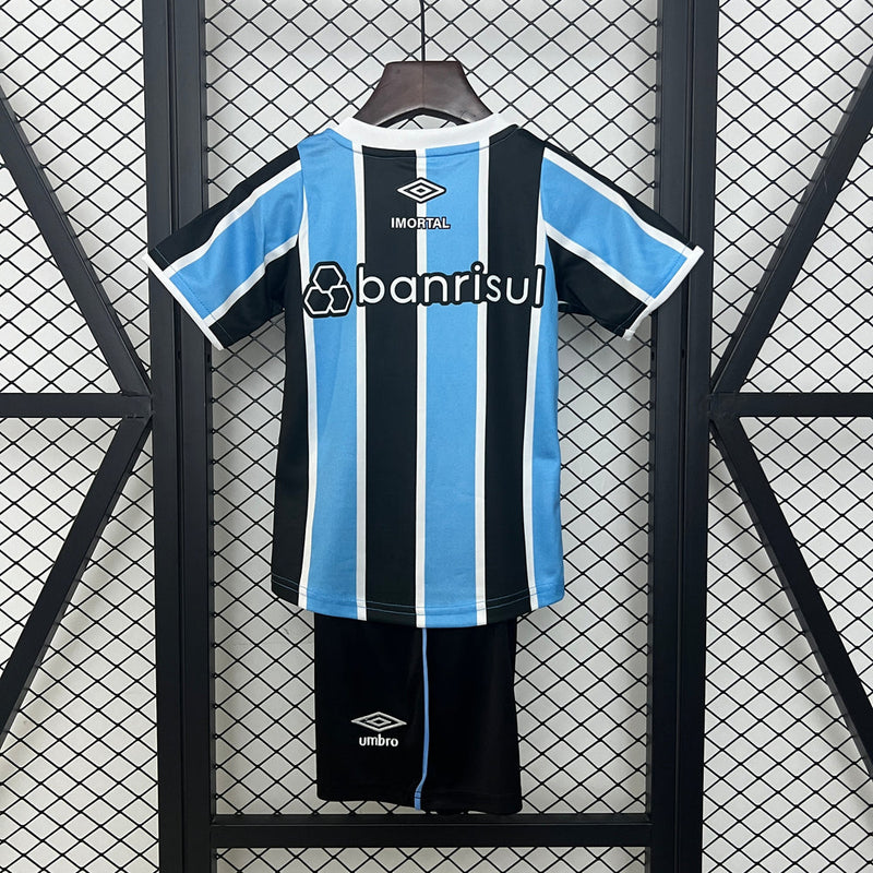 "Kit Infantil Grêmio Home 2024/25 Umbro, camisa azul, preta e branca listrada com shorts e meias combinando, uniforme oficial para crianças de 3 a 13 anos torcedoras do Grêmio."