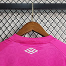 Imagem da Camisa Santos 2023/24 Umbro Torcedor Masculina na cor rosa, com escudo do Santos FC bordado no peito e detalhes em branco e preto.