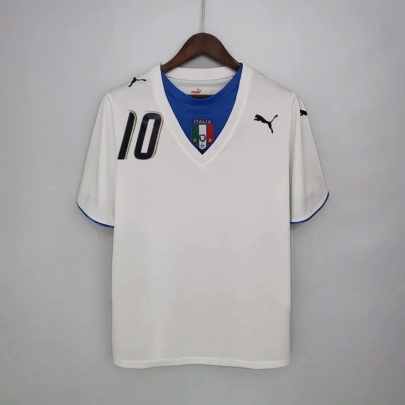 Camisa Itália Away II 2006/07 Puma Retrô masculina, branca, com escudo da seleção italiana no peito e detalhes clássicos da temporada 2006/07, feita em tecido leve e confortável, ideal para colecionadores, fãs de futebol retrô e uso casual.”