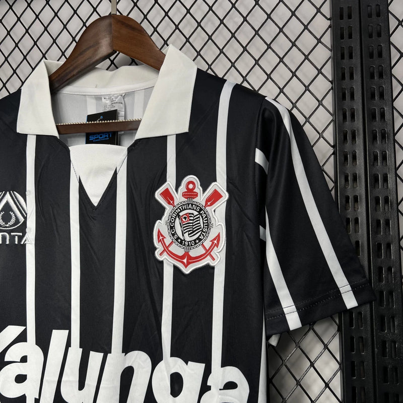 Camisa Corinthians away 1990/91 finta retro masculina com listras verticais em preto e branco, gola polo preta e escudo Bordado mó peito modelo clássico dos anos 90