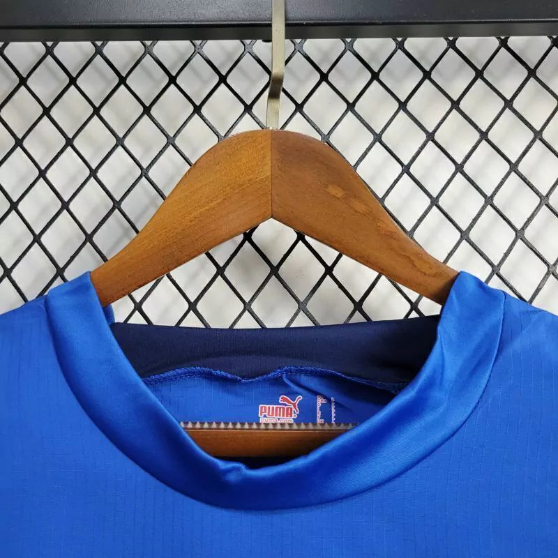 Camisa Itália Home I 2006/07 Puma Retrô Masculina, azul, com escudo da seleção italiana e logo Puma bordados, feita em tecido leve e confortável, modelo retrô masculino com caimento tradicional.”