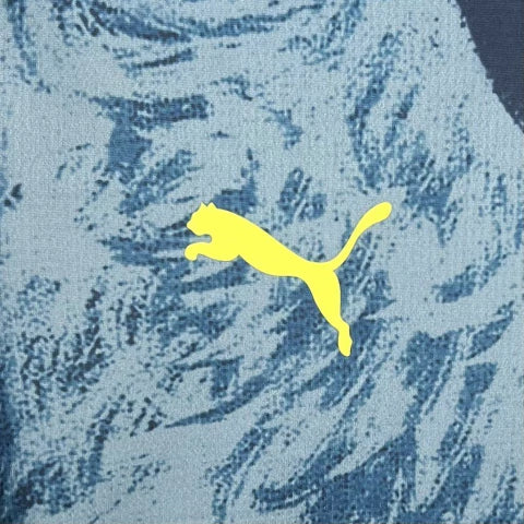 Camisa Fenerbahçe Canário 2025/26 Puma Torcedor Masculina azul, com escudo bordado no peito, detalhes em amarelo e dourado, gola redonda moderna e tecido dryCELL respirável, representando o estilo, tradição e paixão do torcedor do clube turco.