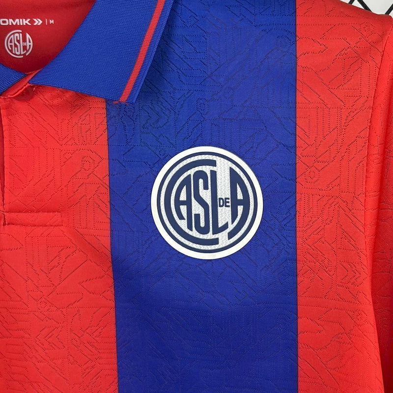 Camisa San Lorenzo Home I 2025/26 Torcedor Masculina azul com detalhes em vermelho, escudo estampado do clube argentino e tecido leve e respirável para torcedores."
