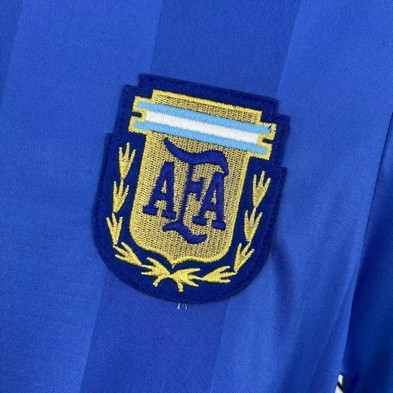 Camisa Argentina Away II 1986/87 Le Coq Sportif retrô masculina, azul escuro com detalhes em branco, escudo da AFA bordado no peito, gola clássica e mangas tradicionais, modelo histórico da seleção argentina após a Copa do Mundo de 1986.