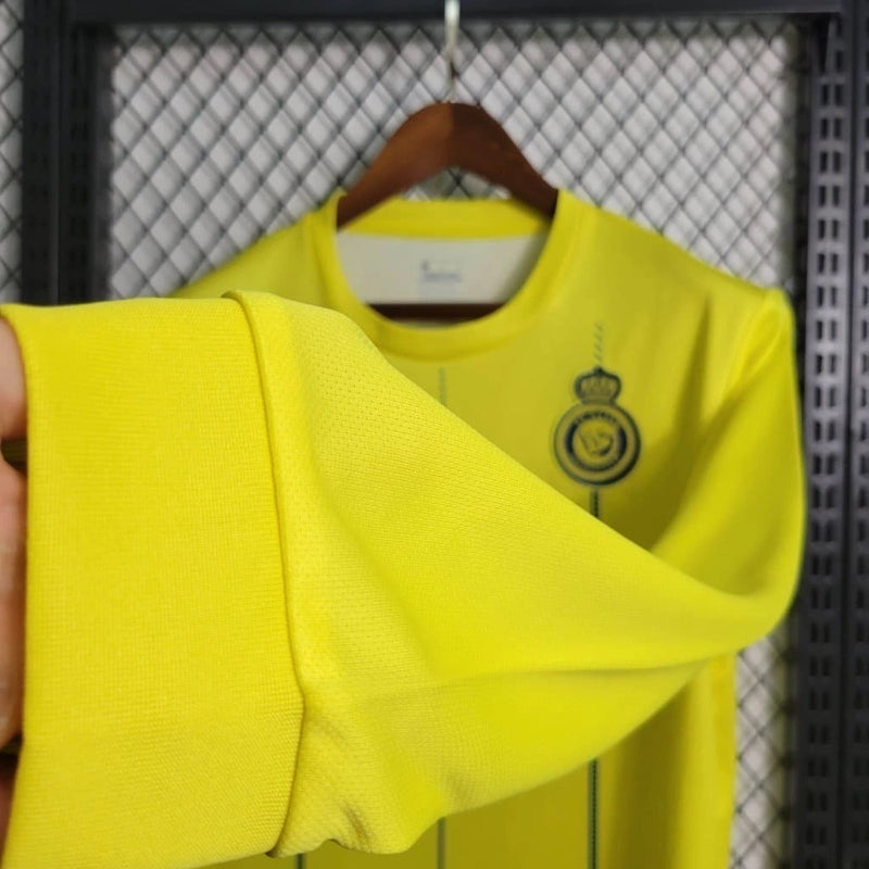 Camisa Al-Nassr Home (1) 2023/24 Nike Torcedor Manga Longa Masculina amarela com detalhes azuis, escudo oficial do Al-Nassr no peito e tecnologia Nike Dri-FIT."
