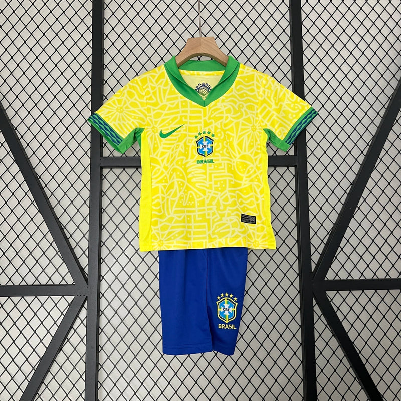 Kit Infantil Brasil Home 2024/25 Nike, camisa amarela com detalhes em verde e azul, shorts e meias combinando, uniforme oficial da Seleção Brasileira para torcedores mirins.