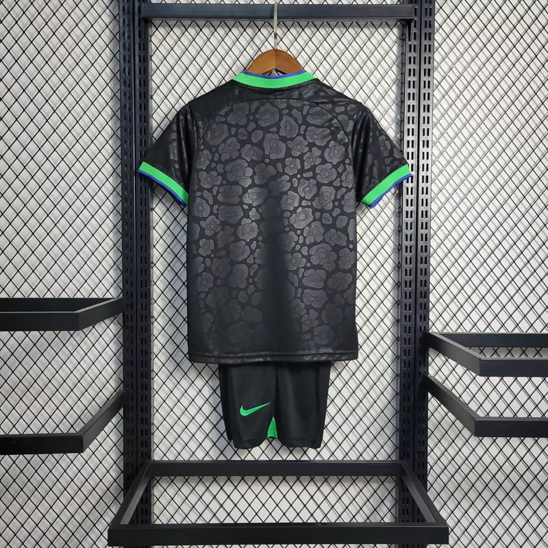 Kit Infantil Brasil 2023/24 Nike, camisa preta com detalhes em verde, shorts e meias combinando, uniforme oficial para crianças de 3 a 13 anos torcedoras da Seleção Brasileira."
