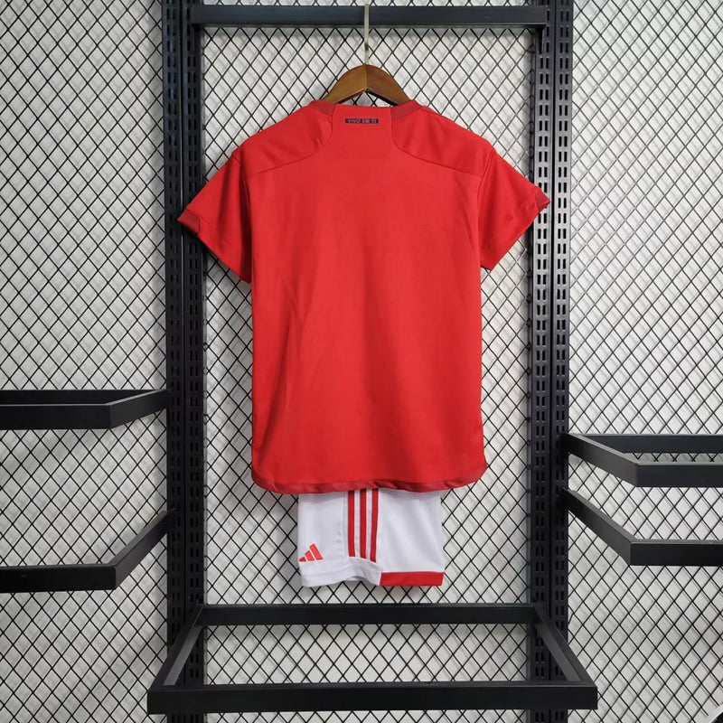 Kit Infantil Internacional Home 2022/23 Adidas, camisa vermelha com detalhes em branco, shorts e meias combinando, uniforme oficial para torcedores mirins do Internacional FC."