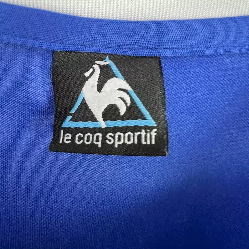 Camisa Argentina Away II 1986/87 Le Coq Sportif retrô masculina, azul escuro com detalhes em branco, escudo da AFA bordado no peito, gola clássica e mangas tradicionais, modelo histórico da seleção argentina após a Copa do Mundo de 1986.