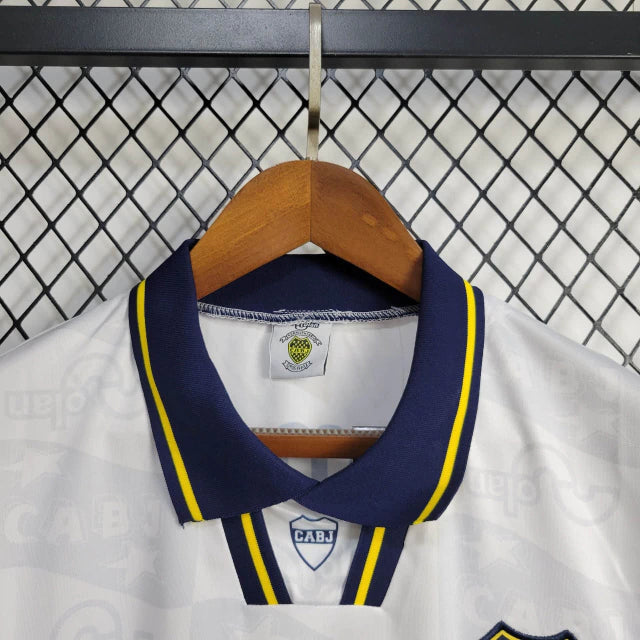 Camisa Boca Juniors Away (2) 1992/96 Olan Retrô Masculina azul escura com faixa amarela horizontal, gola polo com botões e escudo bordado clássico.
