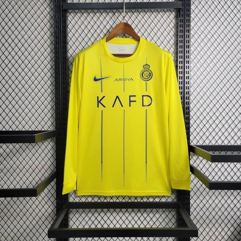 Camisa Al-Nassr Home (1) 2023/24 Nike Torcedor Manga Longa Masculina amarela com detalhes azuis, escudo oficial do Al-Nassr no peito e tecnologia Nike Dri-FIT."
