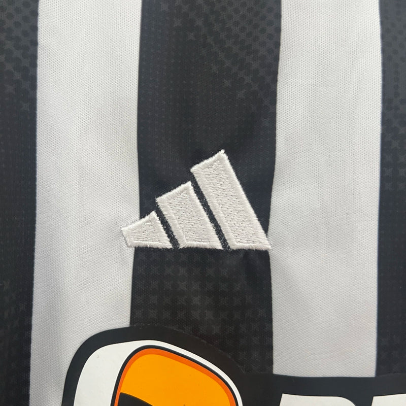 Kit Infantil Atlético Mineiro Home 2024/25 Adidas, camisa listrada preta e branca com shorts e meias, uniforme oficial para crianças torcedoras do Galo."