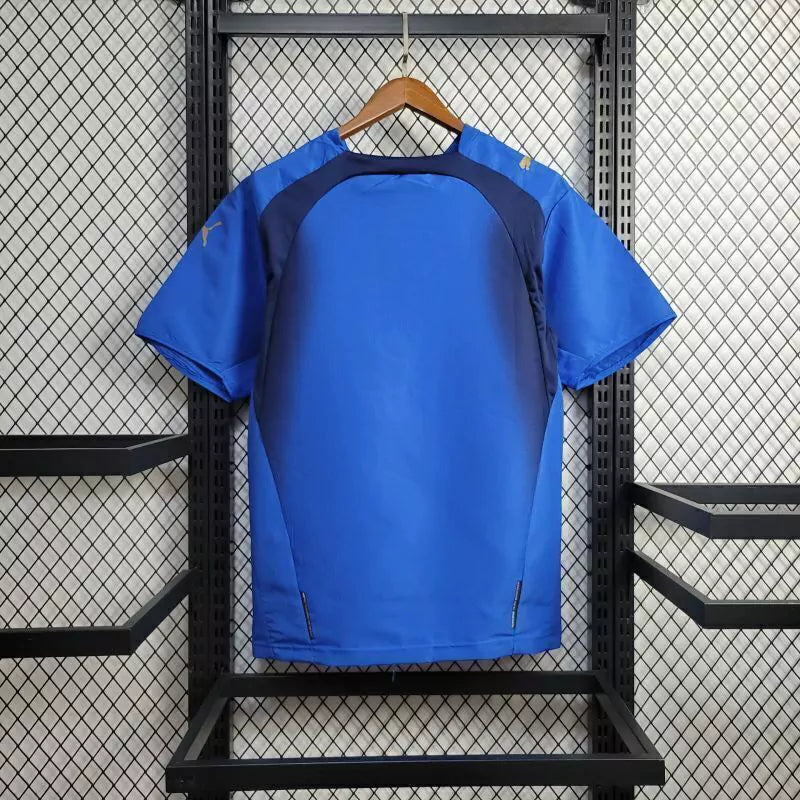 Camisa Itália Home I 2006/07 Puma Retrô Masculina, azul, com escudo da seleção italiana e logo Puma bordados, feita em tecido leve e confortável, modelo retrô masculino com caimento tradicional.”