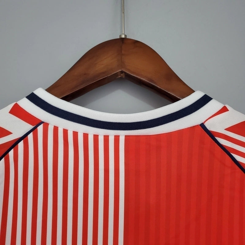 Camisa Dinamarca Home I 1986/87 Hummel Retrô Masculina, vermelha, com escudo da seleção dinamarquesa e logo Hummel bordados, feita em tecido leve e confortável, modelo retrô masculino com caimento tradicional, ideal para colecionadores e uso casual.”