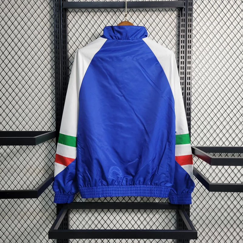 Corta-Vento Itália Edição ICON 2023/24 Adidas Masculino, azul vibrante, com escudo da seleção italiana e logo Adidas em destaque, zíper frontal completo e bolsos funcionais, ideal para torcedores e uso casual.”