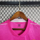 Imagem da Camisa Santos 2023/24 Umbro Torcedor Masculina na cor rosa, com escudo do Santos FC bordado no peito e detalhes em branco e preto.