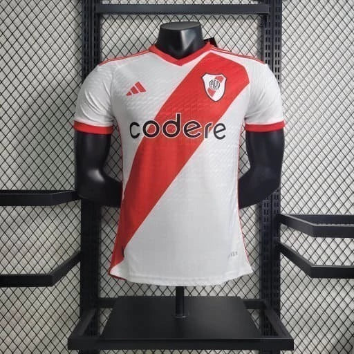 Texto alternativo para imagem:
"Camisa River Plate Home (1) 2023/24 Adidas Jogador Masculina branca com faixa diagonal vermelha, escudo aplicado em silicone 3D, logo Adidas e tecnologia HEAT.RDY, versão oficial usada pelos jogadores."

