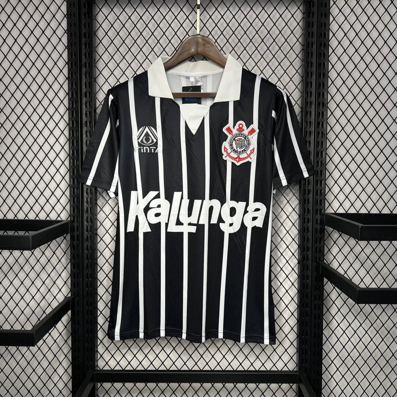 Camisa Corinthians away 1990/91 finta retro masculina com listras verticais em preto e branco, gola polo preta e escudo Bordado mó peito modelo clássico dos anos 90