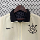 Detalhe da camisa Nike Corinthians 110 Anos 2023 bege com escudo do clube e tecido tecnológico.