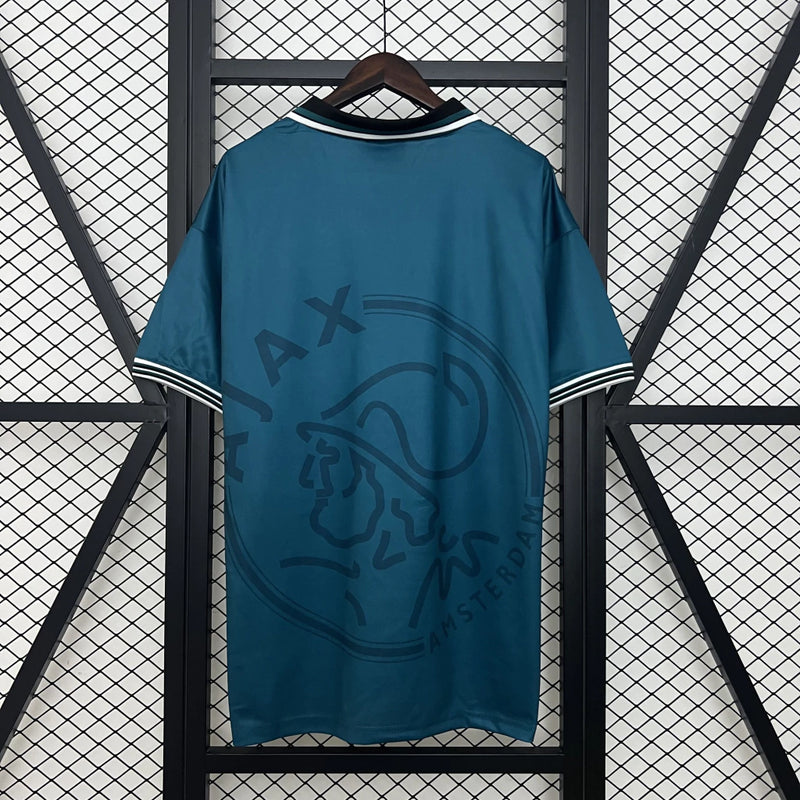 Camisa Ajax Away (2) 1995/96 Umbro Retrô Masculina azul com detalhes vermelhos e brancos, escudo clássico bordado e design vintage dos anos 90"