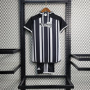 Kit Infantil Atlético Mineiro Home (1) 2023/24 Adidas – camisa listrada preta e branca com escudo bordado, shorts preto e meiões inclusos, uniforme oficial para pequenos torcedores do Galo."
