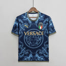 Camisa Concept Itália x Versace Puma Torcedor masculina, azul, com escudo da seleção italiana no peito, detalhes exclusivos da Versace e três listras Puma nos ombros, feita em tecido leve e respirável, modelo com caimento confortável, ideal para torcer com estilo e exclusividade.”