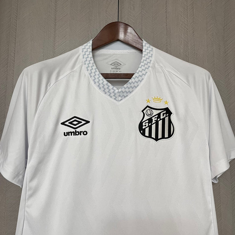 Camisa Santos Home I 2025/26 Umbro Torcedor Masculina branca, com escudo do Santos bordado no lado esquerdo do peito e logo Umbro no lado direito, modelo de jogo, versão torcedor, fundo branco.