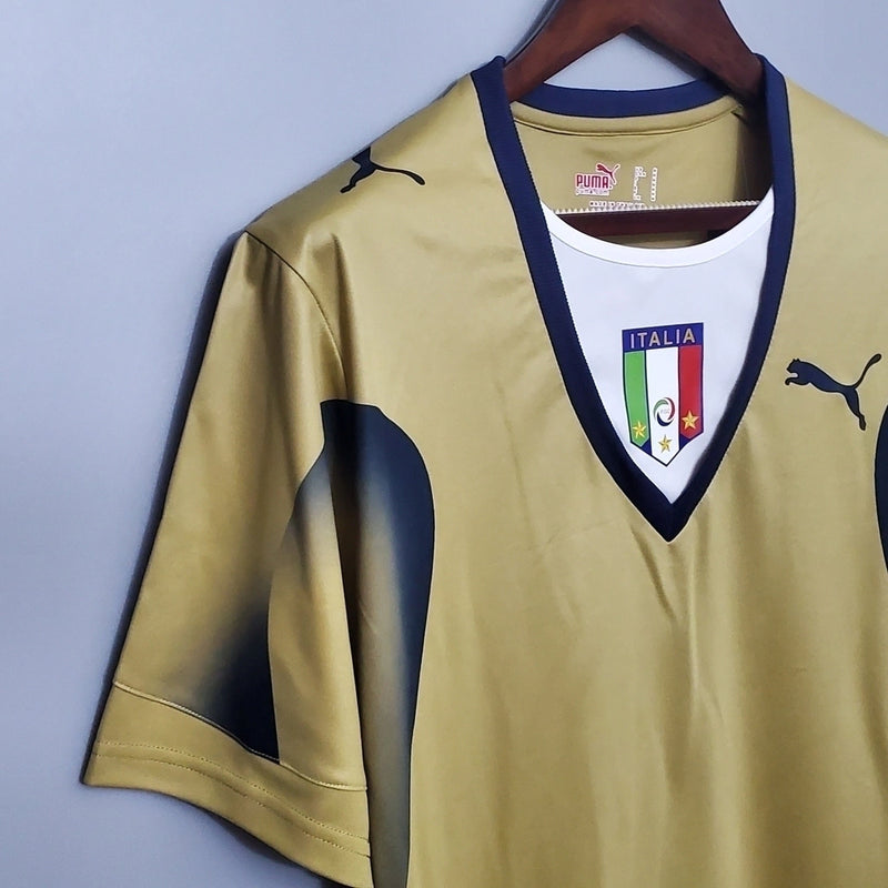 Camisa Itália Goleiro 2006/07 Puma Retrô masculina, dourada, com escudo da seleção italiana no peito e detalhes clássicos da temporada 2006/07, feita em tecido leve e confortável, ideal para colecionadores, fãs de futebol histórico e uso casual.”