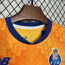 Kit Infantil FC Porto Away II 2024/25 New Balance completo com camisa, shorts e meias, oficial, com escudo do clube, cores azul e laranja, design moderno e confortável para crianças de 3 a 13 anos"
