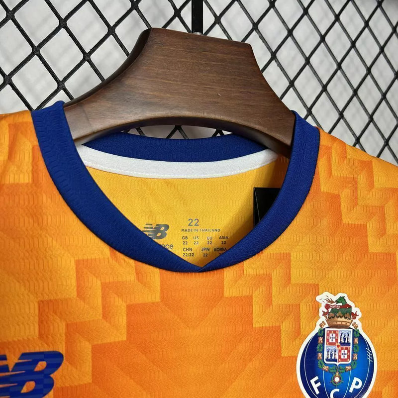 Kit Infantil FC Porto Away II 2024/25 New Balance completo com camisa, shorts e meias, oficial, com escudo do clube, cores azul e laranja, design moderno e confortável para crianças de 3 a 13 anos"
