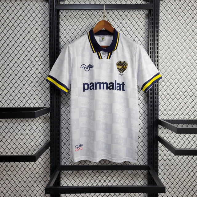Camisa Boca Juniors Away (2) 1992/96 Olan Retrô Masculina azul escura com faixa amarela horizontal, gola polo com botões e escudo bordado clássico.
