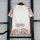 Camisa 1. FC Köln 'Kölsch Mädche' 2024/25 Hummel Torcedor Masculina branca com detalhes vermelhos e pretos, escudo bordado do clube e logo Hummel, modelo oficial para torcedores do futebol alemão.
