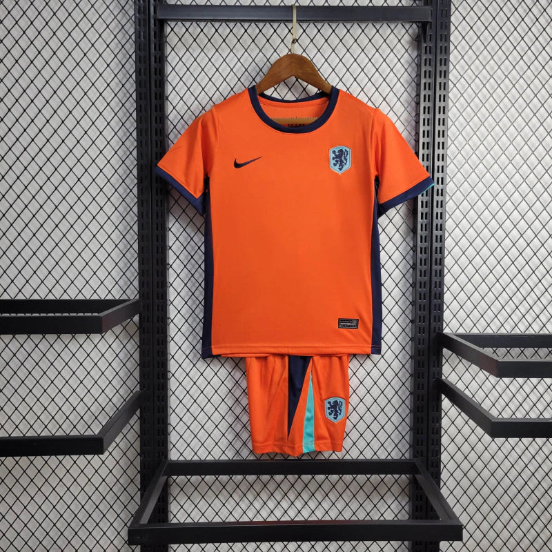 "Kit Infantil Holanda Home (1) 2024/25 Nike oficial, camisa laranja vibrante com escudo KNVB em destaque, shorts combinando, uniforme completo para crianças de 3 a 13 anos"