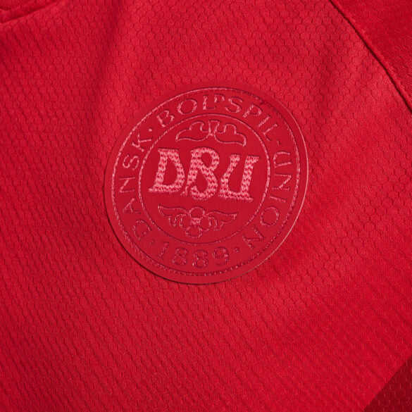 Camisa Dinamarca Home I 2022/23 Hummel Torcedor Masculina, vermelha, com escudo da seleção dinamarquesa e logo Hummel em destaque, feita em tecido leve e respirável, modelo masculino com caimento confortável, ideal para jogos e uso casual.”