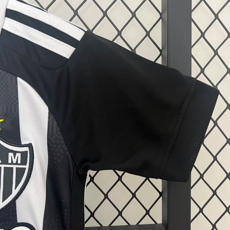 Kit Infantil Atlético Mineiro Home 2024/25 Adidas, camisa listrada preta e branca com shorts e meias, uniforme oficial para crianças torcedoras do Galo."
