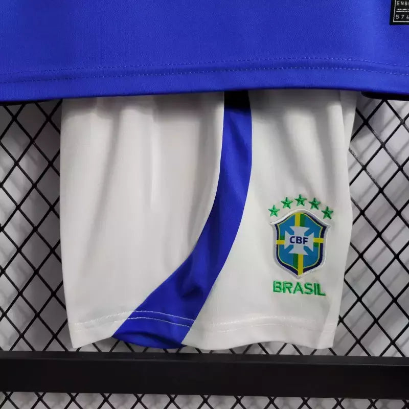 Kit Infantil Brasil Away 2022/23 Nike, camisa azul com detalhes em branco, shorts e meias combinando, uniforme oficial para crianças de 3 a 13 anos torcedoras da Seleção Brasileira."