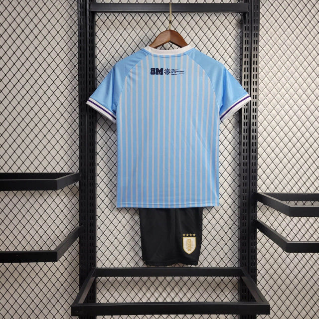"Kit Infantil Uruguai Home (1) 2024/25 oficial, camisa celeste com escudo da AUF em destaque, shorts combinando, uniforme completo para crianças de 3 a 13 anos"
