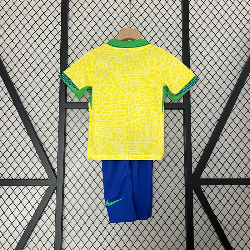 Kit Infantil Brasil Home 2024/25 Nike, camisa amarela com detalhes em verde e azul, shorts e meias combinando, uniforme oficial da Seleção Brasileira para torcedores mirins.