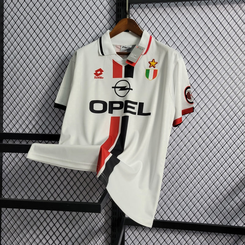 Camisa AC Milan Away (2) 1995/97 Opel Retrô Masculina, uniforme histórico branco com detalhes em vermelho e preto, disponível nos tamanhos P ao XGG, ideal para colecionadores e torcedores."