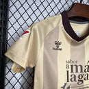 Kit Infantil Málaga CF Third III 2024/25 Hummel com camisa e short dourados, uniforme infantil leve e respirável, ideal para jogos, treinos e jovens torcedores do Málaga CF."