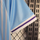 "Kit Infantil Uruguai Home (1) 2024/25 oficial, camisa celeste com escudo da AUF em destaque, shorts combinando, uniforme completo para crianças de 3 a 13 anos"
