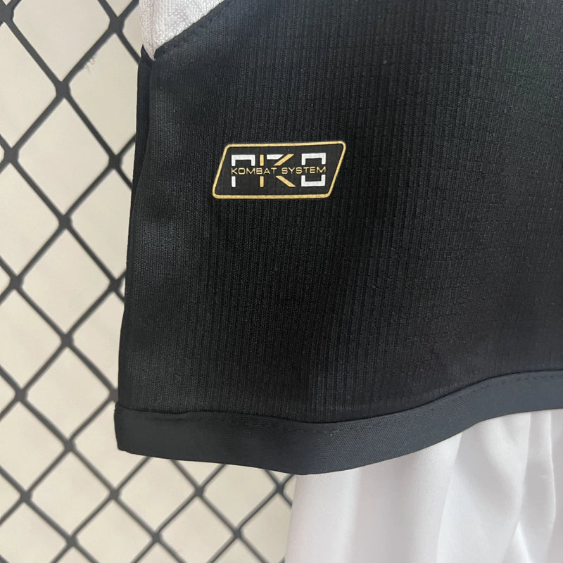 Kit Infantil Vasco Home (1) 2024/25 Kappa – uniforme oficial infantil com camisa branca e faixa diagonal preta, escudo bordado e short, ideal para pequenos torcedores do Vasco da Gama."
