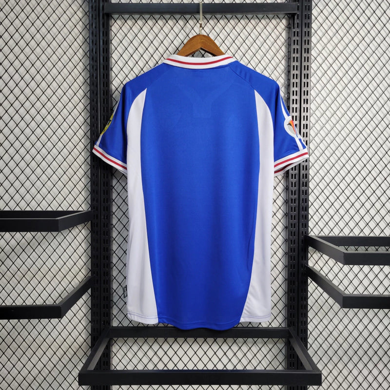 Camisa Iugoslávia 2000/01 Adidas retrô masculina azul com detalhes em branco e vermelho, gola polo com botão e mangas curtas, modelo clássico em tecido leve para torcedores e colecionadores"