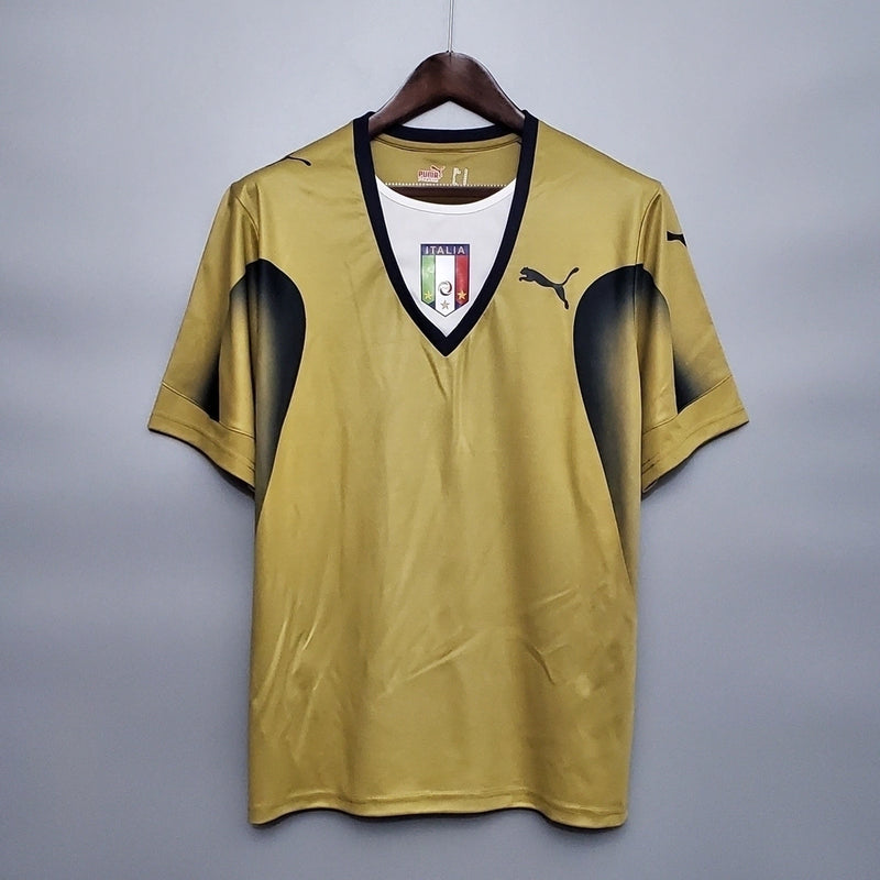 Camisa Itália Goleiro 2006/07 Puma Retrô masculina, dourada, com escudo da seleção italiana no peito e detalhes clássicos da temporada 2006/07, feita em tecido leve e confortável, ideal para colecionadores, fãs de futebol histórico e uso casual.”