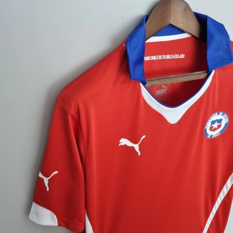 Camisa do Chile 2014 retrô masculina Puma vermelha, modelo Home Copa do Mundo, uniforme clássico da seleção chilena com gola polo azul, escudo bordado e tecido leve."
camisa do Chile 2014
camisa retrô Chile masculina
camisa Puma seleção chilena
camisa Copa do Mundo Chile