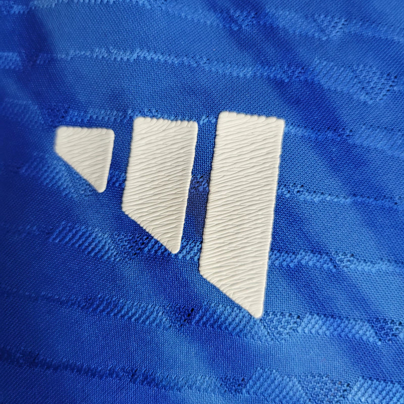 Camisa Itália Home I 2023/24 Adidas Jogador masculina, azul, com escudo da seleção italiana no peito e três listras Adidas nos ombros, feita em tecido leve e respirável, modelo com ajuste jogador para caimento próximo ao corpo, ideal para torcer com estilo e desempenho.”