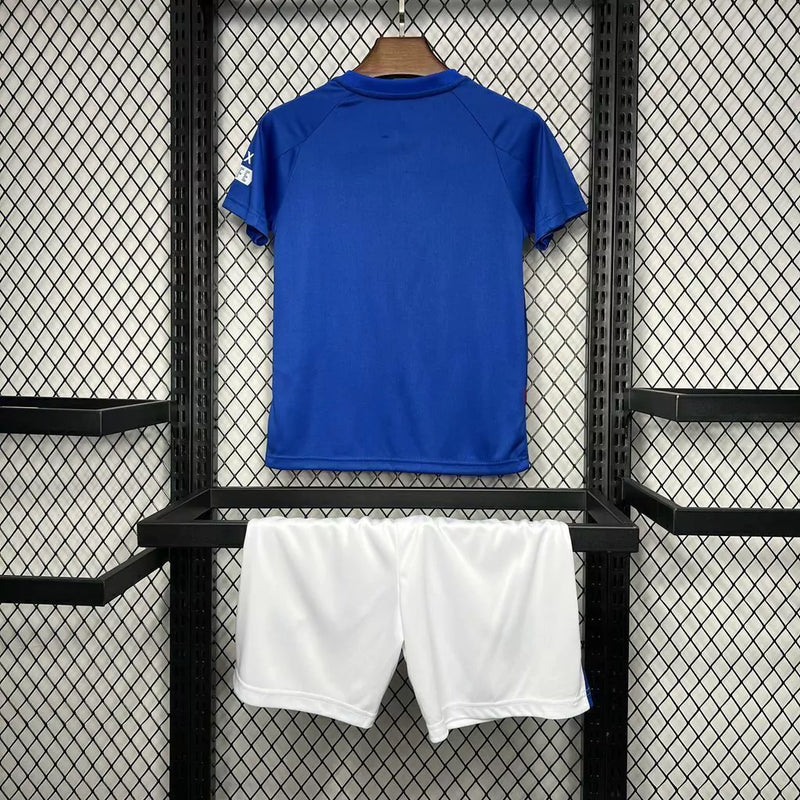 Kit Infantil Rangers FC Home (1) 2024/25 Castore completo com camisa azul, shorts e meias, oficial, escudo do clube em destaque, design moderno e confortável para crianças de 3 a 13 anos"